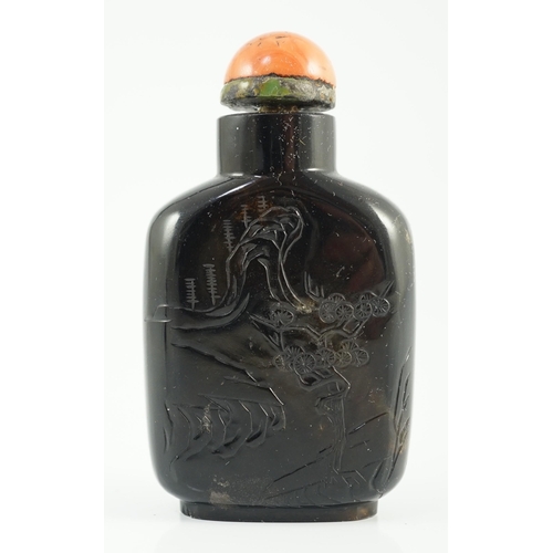 190 - A Chinese smoky quartz snuff bottle, 1780-1820, of flattened shield shape, the carver skilfully usin... 