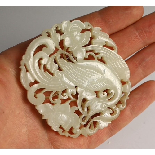 202 - A Chinese white jade phoenix and peony reticulated plaque, early 19th century, the phoenix with sc... 