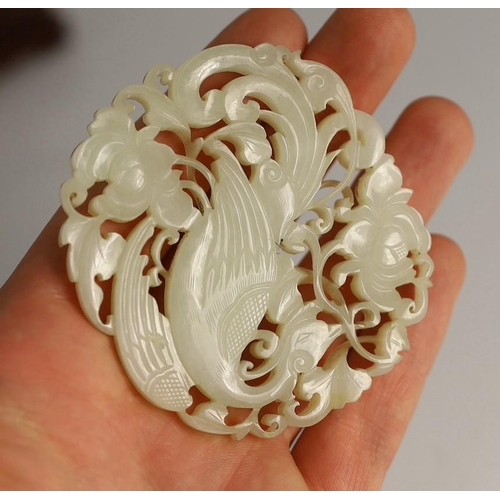 202 - A Chinese white jade phoenix and peony reticulated plaque, early 19th century, the phoenix with sc... 