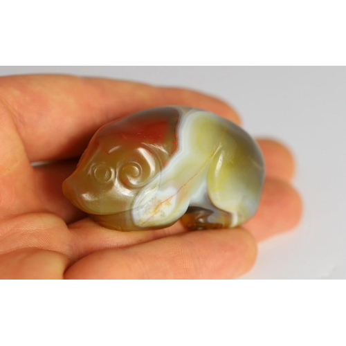 205 - A Chinese banded agate figure of a recumbent pig, 18th/19th century, 5.4cm long, wood stand