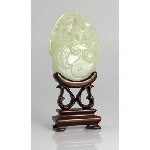 209 - A Chinese white and russet skin jade oval plaque, 19th century, skilfully carved in relief and openw... 