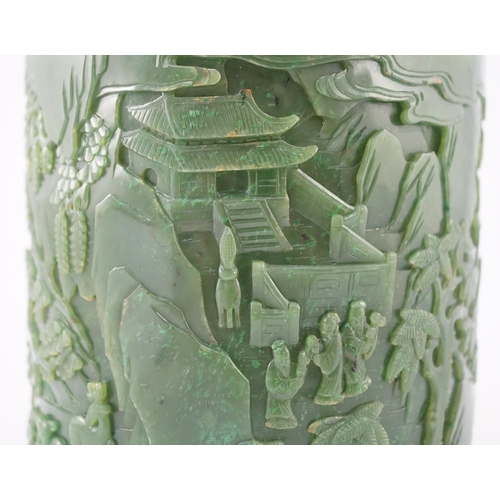 215 - A large Chinese spinach green jade brushpot, bitong, carved in relief with scholars amid pavilions, ... 