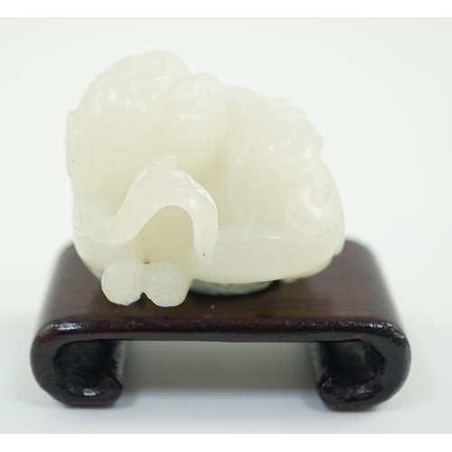 219 - A Chinese white jade figure of a pug dog, 19th/20th century, the dog biting a sprig of lingzhi fungu... 