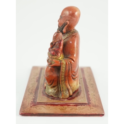 224 - A Chinese soapstone group of a luohan holding a figure of Buddha, 18th century, wearing flowing robe... 