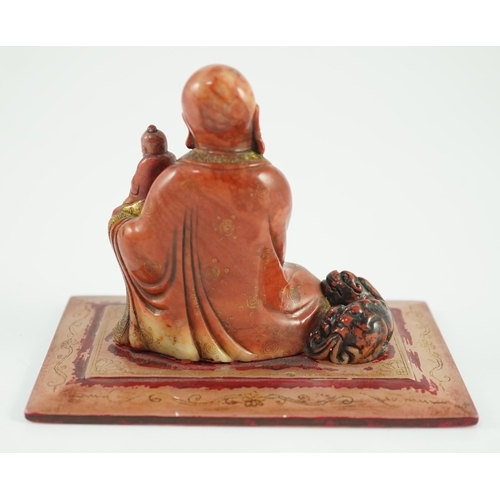 224 - A Chinese soapstone group of a luohan holding a figure of Buddha, 18th century, wearing flowing robe... 