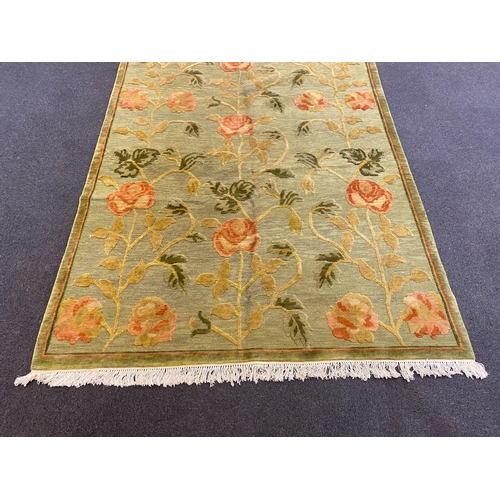 249 - A Tibetan pale green ground carpet, with bold floral field, 250cm x 176cm