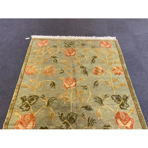 249 - A Tibetan pale green ground carpet, with bold floral field, 250cm x 176cm