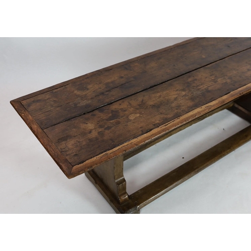 254 - A narrow oak refectory table, part 17th century, the cleated twin plank top above trestle supports w... 