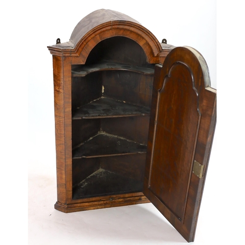 261 - A Queen Anne walnut hanging corner cupboard, with arched cornice and single arched door above a cand... 