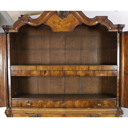 263 - An 18th century Dutch walnut armoire, with scroll moulded cornice and two panelled doors enclosing p... 