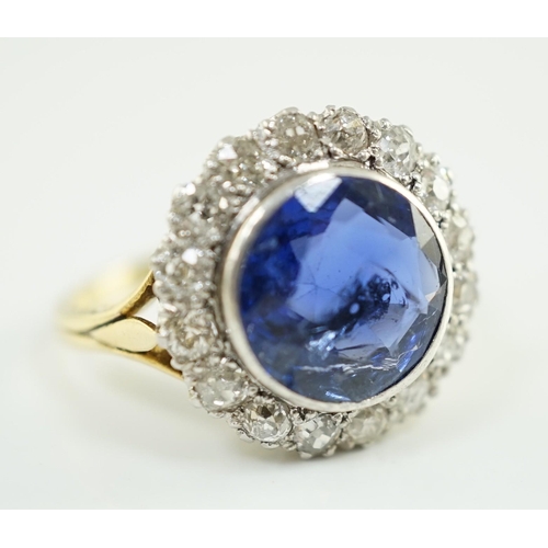 540 - A gold and single stone round cut sapphire set dress ring, with diamond set border, size L/M, gross ... 