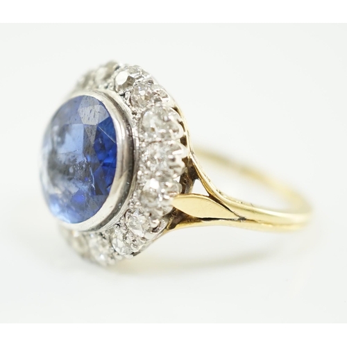 540 - A gold and single stone round cut sapphire set dress ring, with diamond set border, size L/M, gross ... 