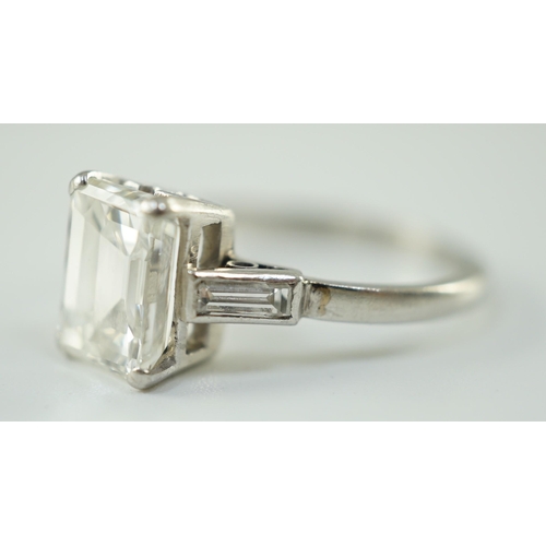 541 - A platinum and single stone emerald cut diamond set ring, with baguette cut diamond set shoulders, t... 