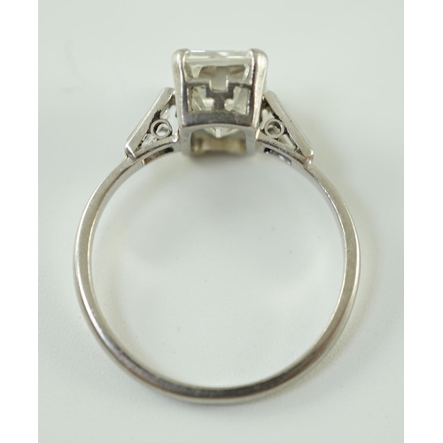 541 - A platinum and single stone emerald cut diamond set ring, with baguette cut diamond set shoulders, t... 