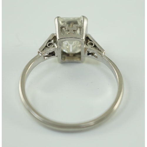 541 - A platinum and single stone emerald cut diamond set ring, with baguette cut diamond set shoulders, t... 