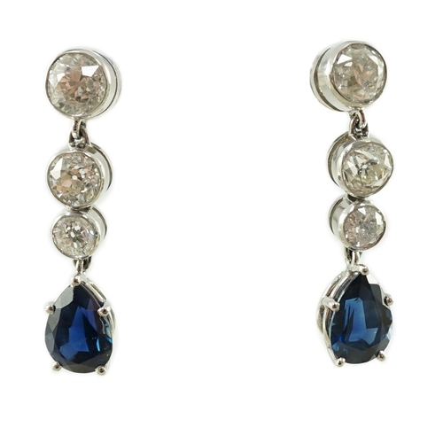 550 - A pair of 1980's platinum, single stone pear cut sapphire and graduated three stone collet set diamo... 