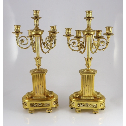 64 - A pair of 19th century French ormolu five light candelabra, with foliate scroll branches and stepped... 