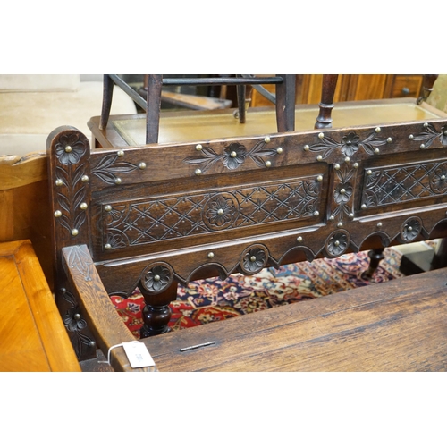 1124 - An 18th century style brass studded carved oak box seat settle, length 136cm, depth 40cm, height 93c... 