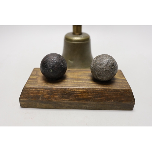 1257 - Two cannon balls, together with a brass hand bell marked A.R.P