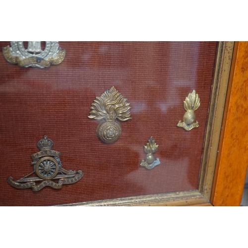 1452 - A framed collection of military cap Badges