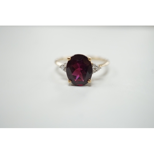 1913 - A modern 9ct gold, single stone oval cut garnet and six stone diamond chip set dress ring, size R/S,... 