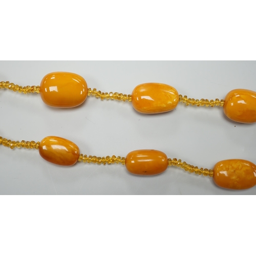 1926 - A single strand graduated fifteen amber bead necklace, with multiple amber? spacers, 84cm, gross wei... 