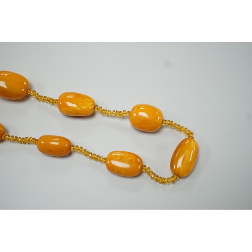 1926 - A single strand graduated fifteen amber bead necklace, with multiple amber? spacers, 84cm, gross wei... 