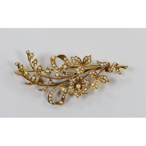 1942 - An Edwardian 15ct and seed pearl set floral spray brooch, 76mm, gross weight 13.5 grams.