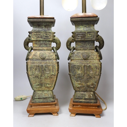 291 - A pair of archaic Chinese bronze vases, converted into table lamps, 62cms high including light fitti... 