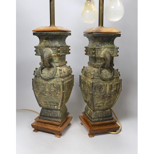 291 - A pair of archaic Chinese bronze vases, converted into table lamps, 62cms high including light fitti... 