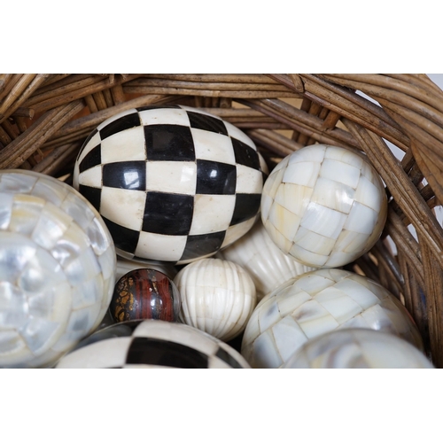 379 - A basket of mother of pearl or bone veneered balls and other decorative balls