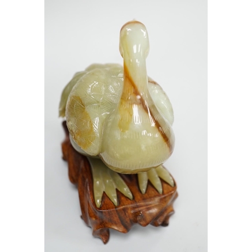 403 - A Chinese green and russet jade figure of a crane, 11.5cm long, wood stand Provenance - the former o... 