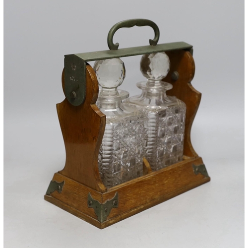 417 - An Edwardian two bottle oak tantalus, 17cms wide