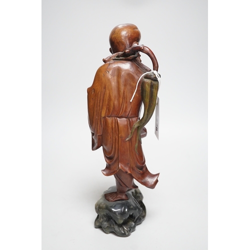 457 - An early 20th century Chinese hardwood carving of a luohan, on soapstone base, 36cm tall