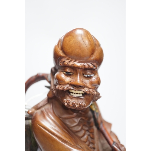 457 - An early 20th century Chinese hardwood carving of a luohan, on soapstone base, 36cm tall