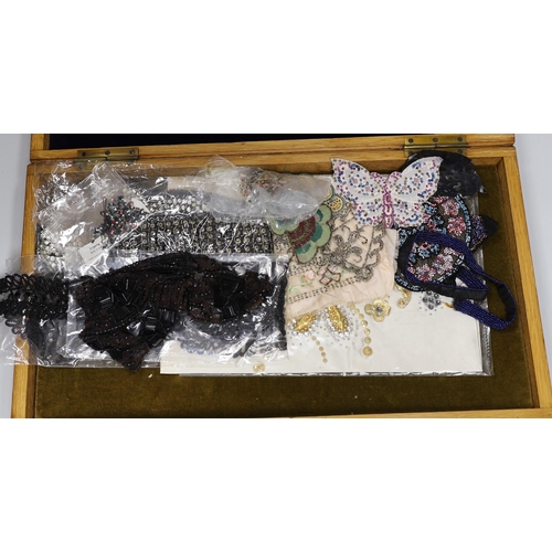 493 - An oak box containing a mixed collection of decorative jet and coloured beaded trimmings, inserts, p... 