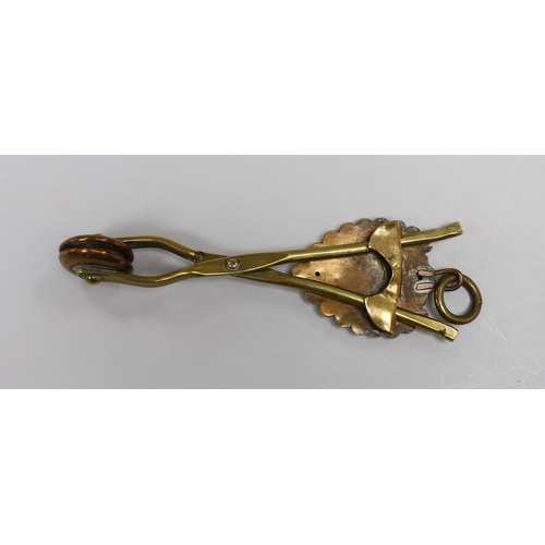 497 - A brass skirt hem lifter. 14cm long