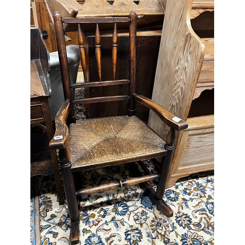 55 - An early 19th century ash rush seat spindle back rocking chair, width 60cm, depth 46cm, height 94cm... 