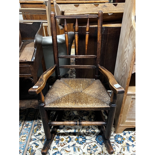 55 - An early 19th century ash rush seat spindle back rocking chair, width 60cm, depth 46cm, height 94cm... 