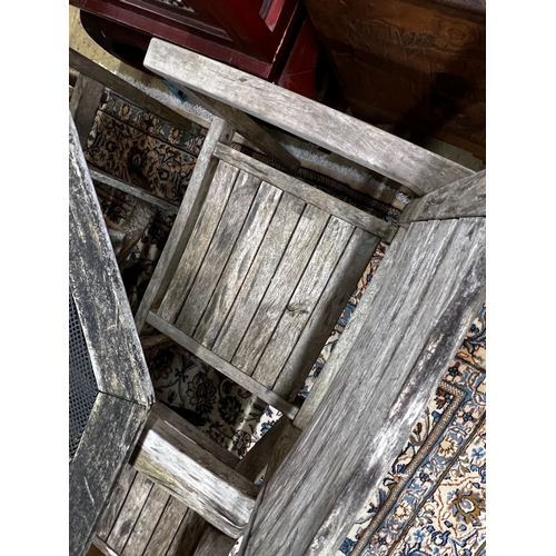 57 - An octagonal weathered teak and mesh garden table, length 103cm, height 74cm together with four teak... 