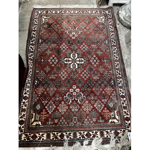 1098 - A North West Persian red ground rug, 170 x 116cm