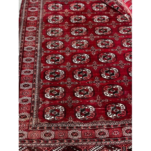 1023 - A Bokhara burgundy red ground rug, 180 x 150cm