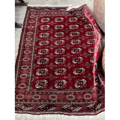 1023 - A Bokhara burgundy red ground rug, 180 x 150cm