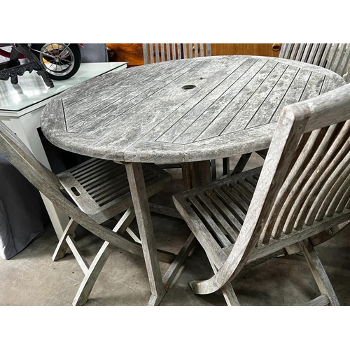 1078 - A Jo Alexander circular weathered teak folding garden table, diameter 120cm, height 75cm and four ch... 