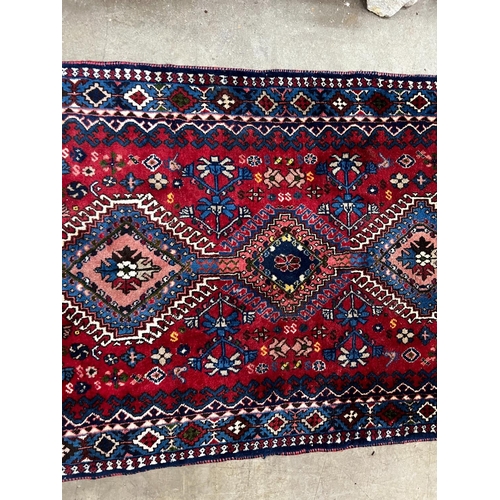 1087 - A Caucasian style red ground runner 200cm x 76cm