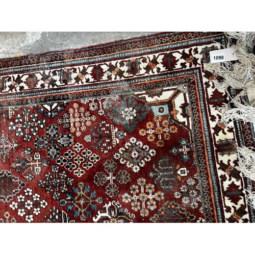 1098 - A North West Persian red ground rug, 170 x 116cm