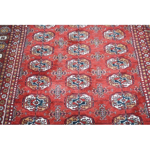 1103 - A Bokhara red ground rug, 186 x 122cm