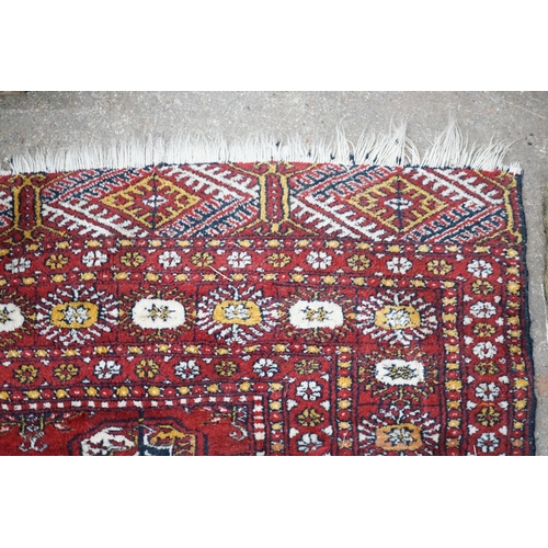 1103 - A Bokhara red ground rug, 186 x 122cm