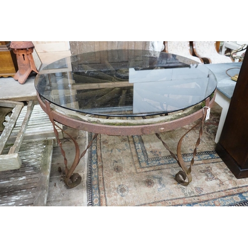 1106 - A wrought iron glass topped circular cartwheel garden table, diameter 124cm, height 72cm