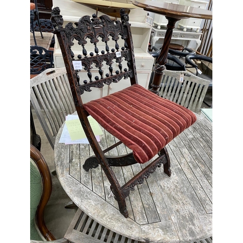 1122 - A late 19th century Flemish carved oak folding chair, height 73cm